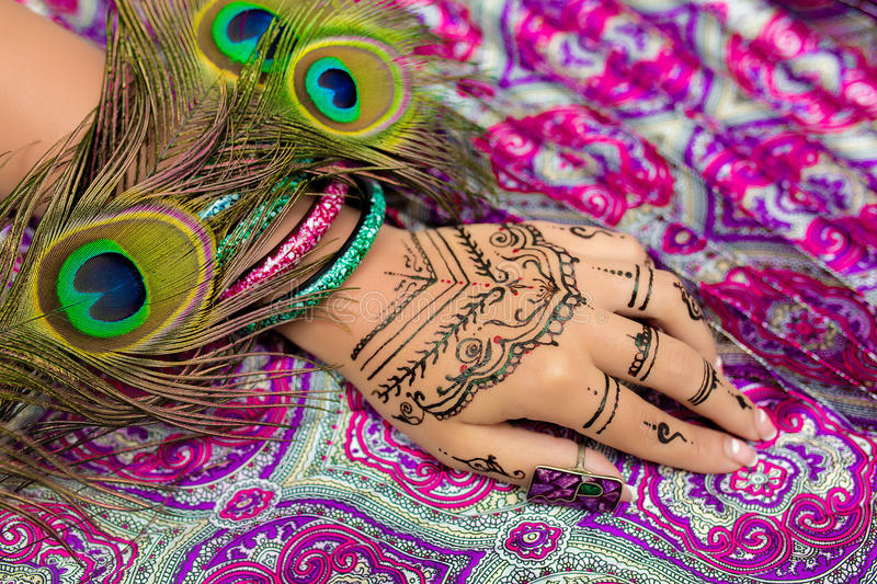 Delicate peacock feather design on the fingers